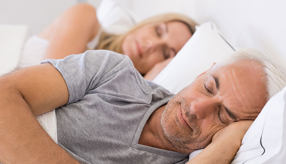 mature couple sleeping peacefully in bed together